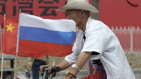 A man rides with a Russian flag displayed on his pedicab in Beijing's Russian trade district of Yabaolu - Sputnik International