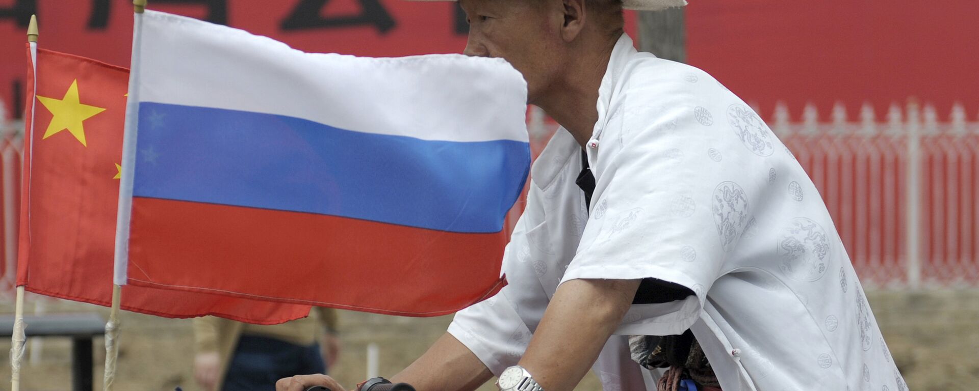 A man rides with a Russian flag displayed on his pedicab in Beijing's Russian trade district of Yabaolu. (File) - Sputnik International, 1920, 20.03.2023