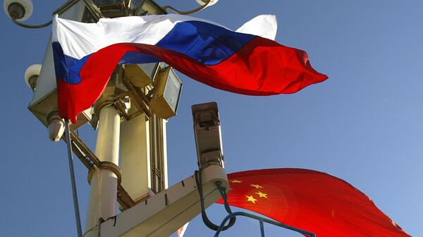A worker places the Russian and Chinese flags outside Tiananmen Gate - Sputnik International