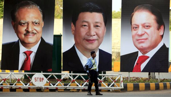 A policeman stands guard next to giant portraits of (L-R) Pakistan's President Mamnoon Hussain, China's President Xi Jinping, and Pakistan's Prime Minister Nawaz Sharif, displayed along a road ahead of Xi's visit to Islamabad - Sputnik International