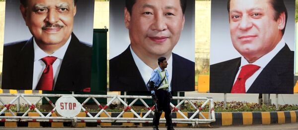 A policeman stands guard next to giant portraits of (L-R) Pakistan's President Mamnoon Hussain, China's President Xi Jinping, and Pakistan's Prime Minister Nawaz Sharif, displayed along a road ahead of Xi's visit to Islamabad A policeman stands guard next to giant portraits of (L-R) Pakistan's President Mamnoon Hussain, China's President Xi Jinping, and Pakistan's Prime Minister Nawaz Sharif, displayed along a road ahead of Xi's visit to Islamabad - Sputnik International