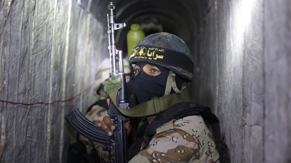 Palestinian militants from the Islamic Jihad's armed wing, the Al-Quds Brigades, squat in a tunnel, used for storing weapons, as they take part in military training in the south of the Gaza Strip on March 3, 2015. - Sputnik International