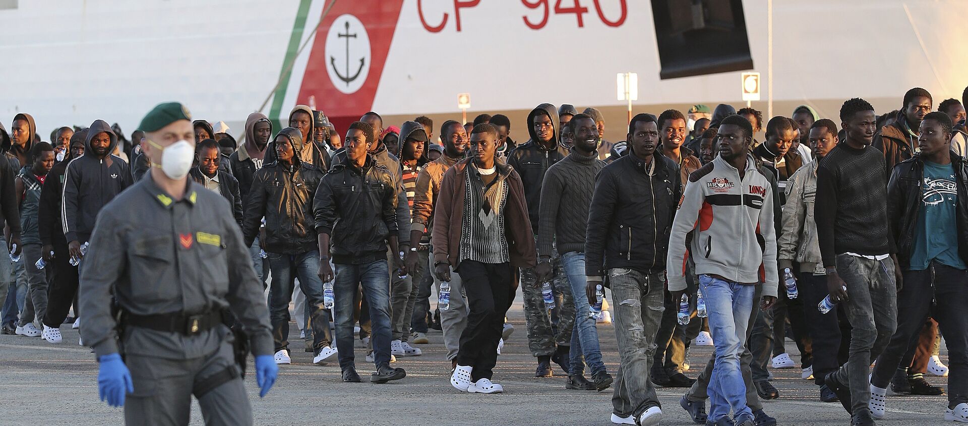 Migrants are disembarked from a Coast Guard boat in the Sicilian harbour of Augusta - Sputnik International, 1920, 02.10.2019