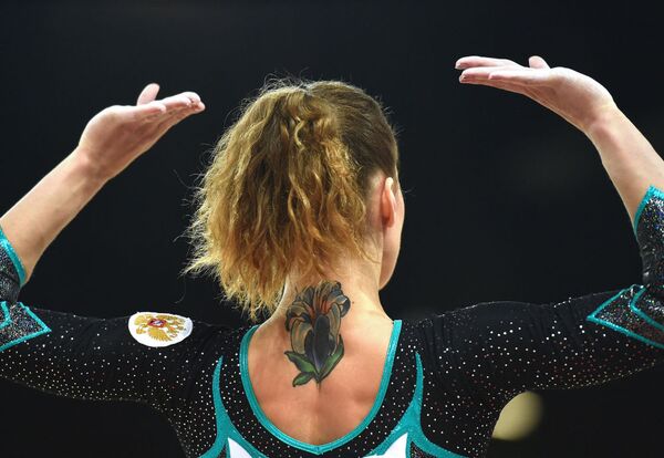 Russia's Maria Ksenia Afanaseva, bearing a tattoo on her neck, competing in the floor exercise event - Sputnik International