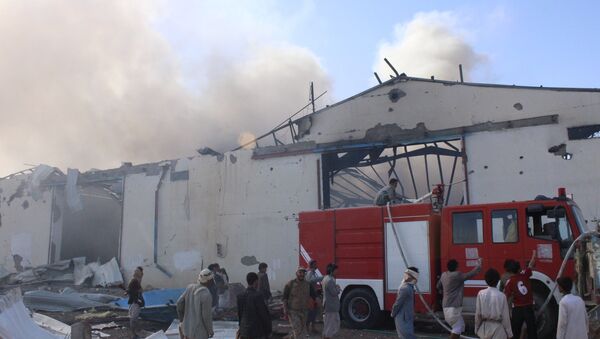 Civil defence workers try to put out the fire caused by an air strike on a food stuff depot in Yemen's northwestern city of Saada April 18, 2015 - Sputnik International