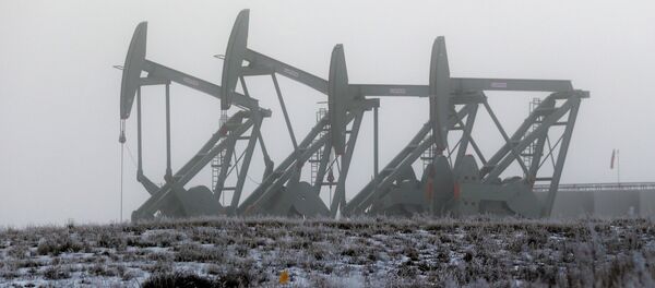 In this Dec. 19, 2014 file photo, oil pump jacks work in unison on a foggy morning in Williston, N.D. The North Dakota Legislature is looking at restructuring oil taxes as a hedge against falling crude prices In this Dec. 19, 2014 file photo, oil pump jacks work in unison on a foggy morning in Williston, N.D. The North Dakota Legislature is looking at restructuring oil taxes as a hedge against falling crude prices - Sputnik International