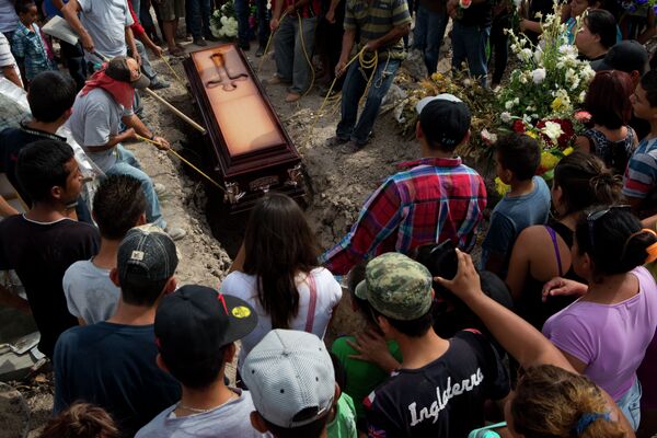 Mourners lower the coffin of shooting victim in Apatzingan, Michoacan state, Mexico. Mourners lower the coffin of shooting victim in Apatzingan, Michoacan state, Mexico. - Sputnik International