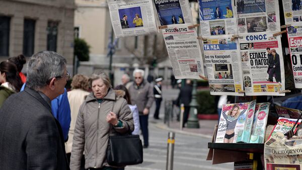 A man reads newspapers' headlines in Athens on March 24, 2015 - Sputnik International