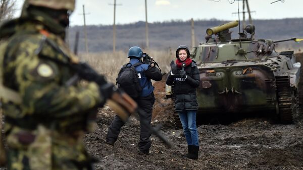 A TV journalist prepares to do a piece to camera in front of an armoured personnel carrier (APC) on the frontline between Ukrainian forces and militants near the eastern Ukrainian city of Debaltseve, in the Donetsk region - Sputnik International