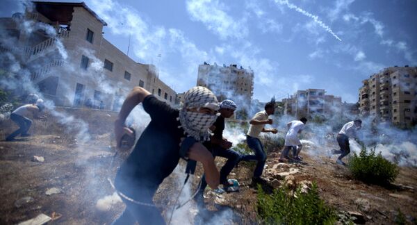 Palestinians run for cover during clashes with Israeli soldiers following a protest against the war in the Gaza Strip in August 2014. Palestinians run for cover during clashes with Israeli soldiers following a protest against the war in the Gaza Strip in August 2014. - Sputnik International