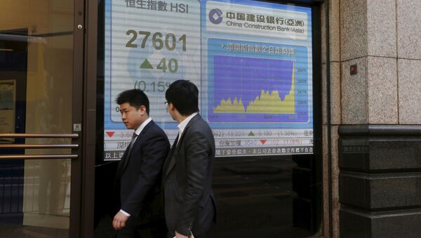 People walk past a panel displaying the benchmark Hang Seng Index during afternoon trading outside a bank in Hong Kong April 15, 2015 - Sputnik International