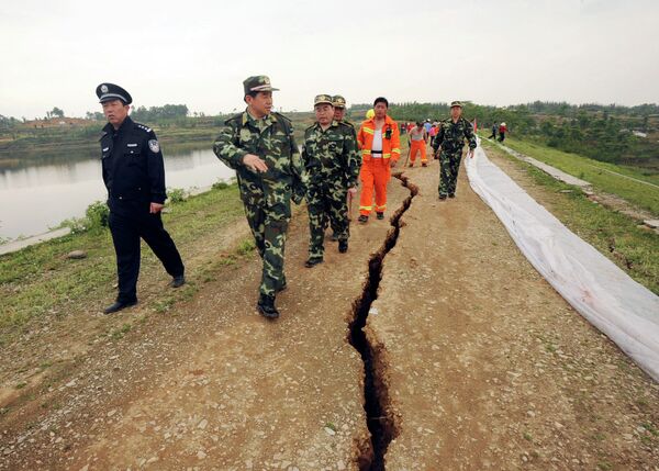 In this photo released by China's Xinhua News Agency, rescuers inspect a crack at Fengshou reservoir dam, caused by Monday's 7.9 magnitude earthquake in Anxian County, southwest China's Sichuan Province, in May 2008. - Sputnik International