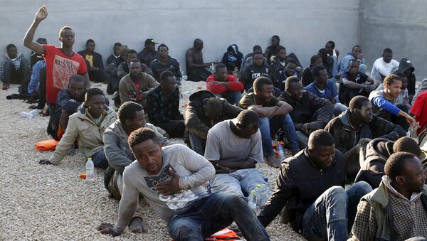 Illegal migrants sit in a coastal police base in Tripoli March 13, 2015 - Sputnik International