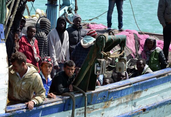 Migrants arrive at the port in the Tunisian town of Zarzis, some 50 kilometres west of the Libyan border, following their rescue by Tunisia's coastguard and navy after their vessel overturned off Libya, on April 13, 2015 Migrants arrive at the port in the Tunisian town of Zarzis, some 50 kilometres west of the Libyan border, following their rescue by Tunisia's coastguard and navy after their vessel overturned off Libya, on April 13, 2015 - Sputnik International