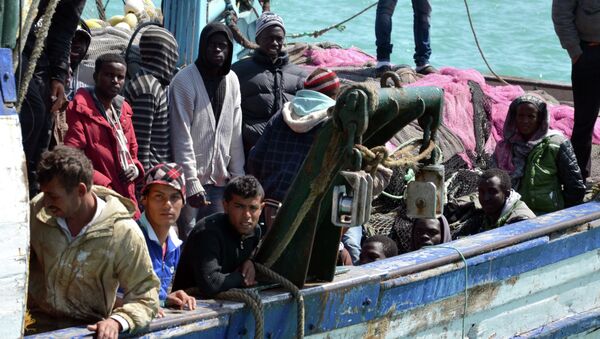 Migrants arrive at the port in the Tunisian town of Zarzis, some 50 kilometres west of the Libyan border, following their rescue by Tunisia's coastguard and navy after their vessel overturned off Libya, on April 13, 2015 - Sputnik International