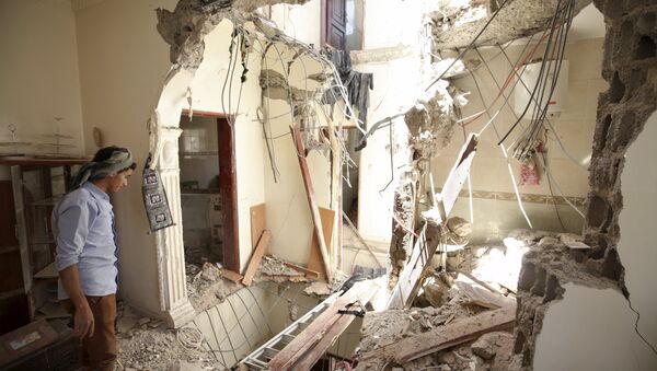 A man looks at damage in his house caused by an April 20 air strike that hit a nearby army weapons depot in Sanaa April 21, 2015 - Sputnik International
