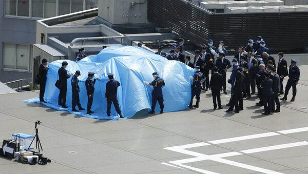 Police and security officials stand around a tarpaulin covering a drone on the roof of Prime Minister Shinzo Abe's official residence in Tokyo April 22, 2015 - Sputnik International