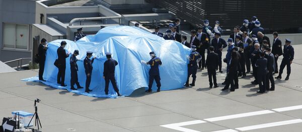 Police and security officials stand around a tarpaulin covering a drone on the roof of Prime Minister Shinzo Abe's official residence in Tokyo April 22, 2015 Police and security officials stand around a tarpaulin covering a drone on the roof of Prime Minister Shinzo Abe's official residence in Tokyo April 22, 2015 - Sputnik International