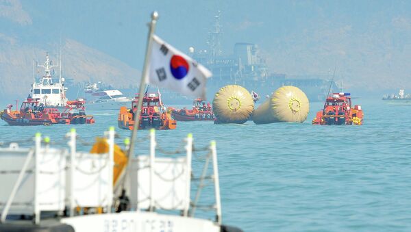 South Korean rescue teams take part in recovery operations at the site of the sunken 'Sewol' ferry, marked with buoys, off the coast of the South Korean island of Jindo  - Sputnik International
