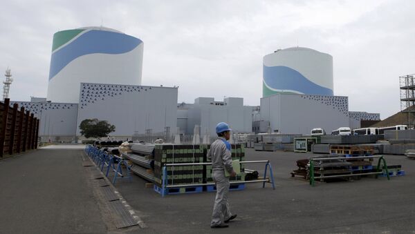An employee of Kyushu Electric Power Co walks in front of reactor buildings at the company's Sendai nuclear power plant in Satsumasendai, Kagoshima prefecture - Sputnik International