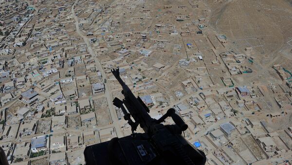 Residential houses and a mounted machine gun manned by an Afghan National Army soldier is pictured during a helicopter flight  - Sputnik International