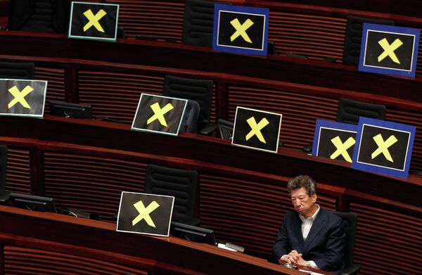 Pro-democracy lawmaker Ronny Tong sits with placards of yellow crosses placed Pro-democracy lawmaker Ronny Tong sits with placards of yellow crosses placed - Sputnik International