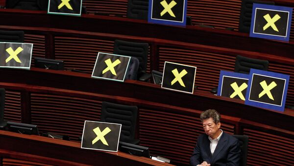 Pro-democracy lawmaker Ronny Tong sits with placards of yellow crosses placed  - Sputnik International