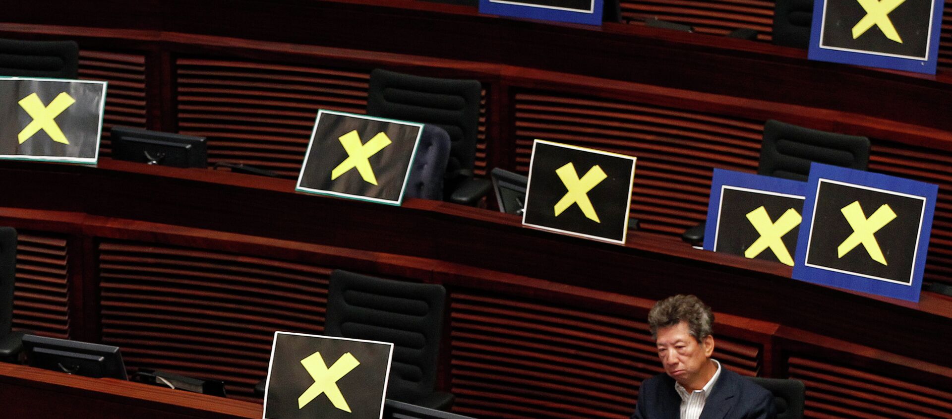 Pro-democracy lawmaker Ronny Tong sits with placards of yellow crosses placed  - Sputnik International, 1920, 22.02.2021