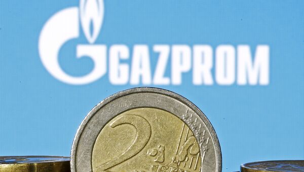 Euro coins are seen in front of displayed logo of Gazprom - Sputnik International