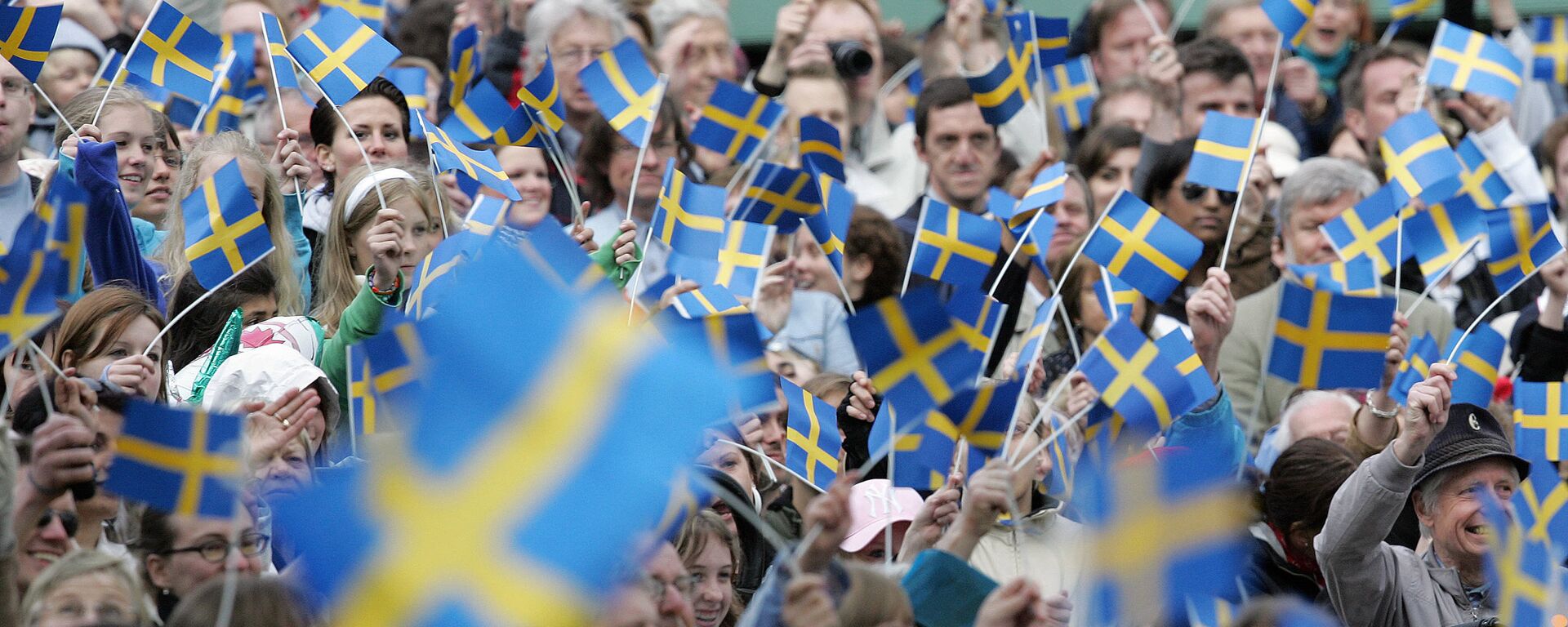 Swedes wave with flags in the Skansen open-air museum in Stockholm 06 June 2005 when the National Day for the first time is celebrated as a national holiday in Sweden - Sputnik International, 1920, 13.03.2023