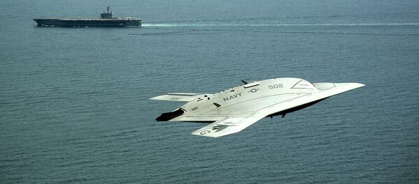 An X-47B Unmanned Combat Air System (UCAS) demonstrator flies near the aircraft carrier USS George H.W. Bush. - Sputnik International