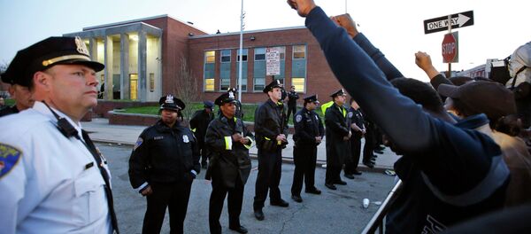 Marchers raise their fists in front of Baltimore police guarding the department's Western District police station during a march for Freddie Gray, Wednesday, April 22, 2015, in Baltimore Marchers raise their fists in front of Baltimore police guarding the department's Western District police station during a march for Freddie Gray, Wednesday, April 22, 2015, in Baltimore - Sputnik International