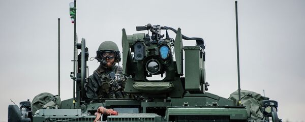 A soldier from the Swedish Armed Forces, looks on from top of the Patria XA-360 AMV (Armored Modular Vehicle) at Hagshult Airbase - Sputnik International