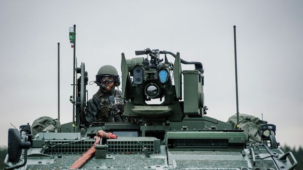 A soldier from the Swedish Armed Forces, looks on from the top of the Patria XA-360 AMV (Armored Modular Vehicle) at Hagshult Airbase. - Sputnik International