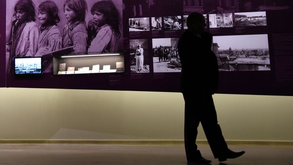 A man stands by archive photographs during an exhibition about the Armenian Genocide at the Armenian Genocide Museum in Yerevan on April 21, 2015 - Sputnik International