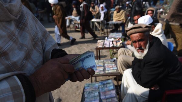 In this photograph taken on December 29, 2014, an Afghan customer (L) counts his Afghani currency notes at a currency exchange market along the roadside in Kabul - Sputnik International