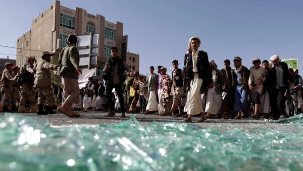 Supporters of the Shiite Huthi movement walk on shattered glass as they take part in a demonstration in the capital Sanaa on April 22, 2015 - Sputnik International