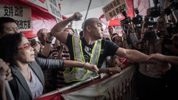 A pro-Beijing protester tries to punch a pro-democracy demonstrator after a heated argument outside the government building in Hong Kong on April 22, 2015. - Sputnik International