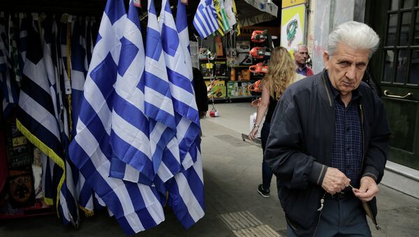 A man walk past a kiosk with Greek flags for sale in central Athens. - Sputnik International
