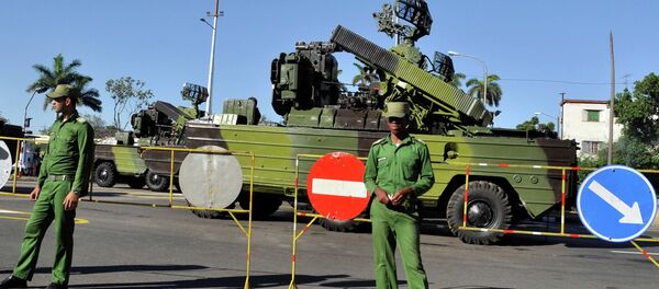 Cuban soldiers guard military vehicles, during a parade rehearsal at Revolution Square in Havana - Sputnik International