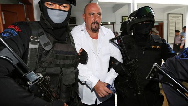 Serge Atlaoui, center, a French national who is on death row after being convicted of drug offences, is escorted by armed police officers upon arrival for his judicial review hearing at the district court in Tangerang, Indonesia. - Sputnik International