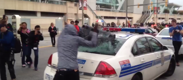 Screenshot from cell phone video that shows a protester smash a police car window during an anti-police brutality rally in Baltimore on April 25, 2015 - Sputnik International