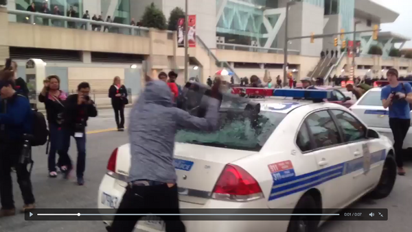 Screenshot from cell phone video that shows a protester smash a police car window during an anti-police brutality rally in Baltimore on April 25, 2015 - Sputnik International