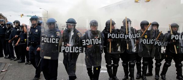 Police advance toward protestors as a store burns, Monday, April 27, 2015, during unrest following the funeral of Freddie Gray in Baltimore. Police advance toward protestors as a store burns, Monday, April 27, 2015, during unrest following the funeral of Freddie Gray in Baltimore. - Sputnik International