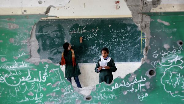 Palestinian girls play inside their school which was destroyed during the 50 days of conflict between Israel and Hamas last summer, in the Shejaiya neighborhood of Gaza City, on November 5, 2014 - Sputnik International