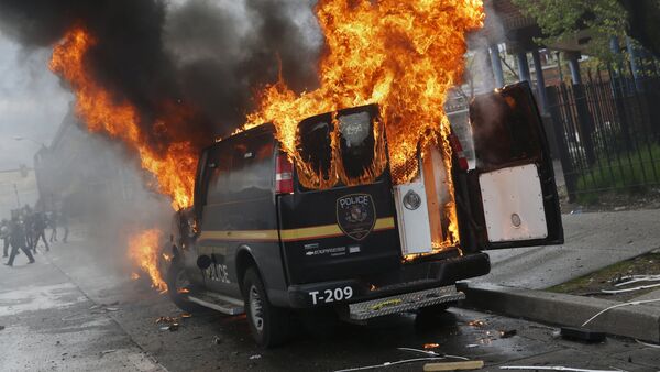 A Baltimore Metropolitan Police transport vehicle burns during clashes in Baltimore, Maryland April 27, 2015 - Sputnik International