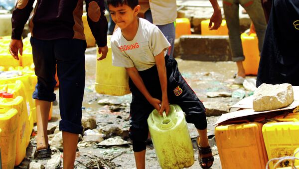 A Yemeni boy carries a jerrycans filled with water from a public tap amid an acute shortage of water supply to houses in the capital Sanaa. - Sputnik International