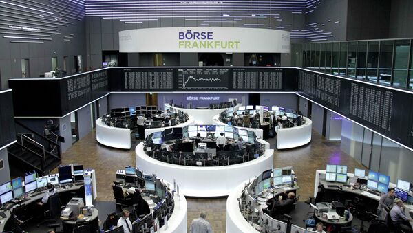 Traders are pictured at their desks in front of the DAX board at the Frankfurt stock exchange April 15, 2015 - Sputnik International