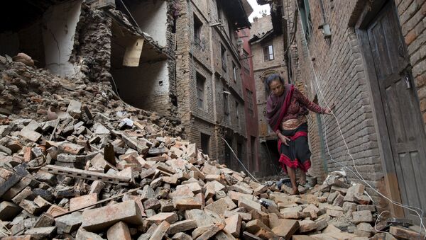 A woman walks across the rubble of a collapsed building following an earthquake in Bhaktapur near Kathmandu, Nepal in this Red Cross handout picture taken on April 28, 2015. - Sputnik International