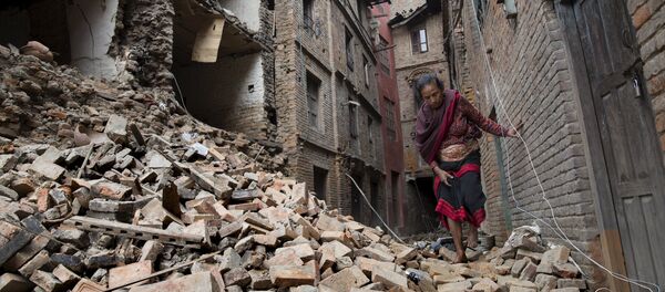 A woman walks across the rubble of a collapsed building following an earthquake in Bhaktapur near Kathmandu, Nepal in this Red Cross handout picture taken on April 28, 2015. A woman walks across the rubble of a collapsed building following an earthquake in Bhaktapur near Kathmandu, Nepal in this Red Cross handout picture taken on April 28, 2015. - Sputnik International